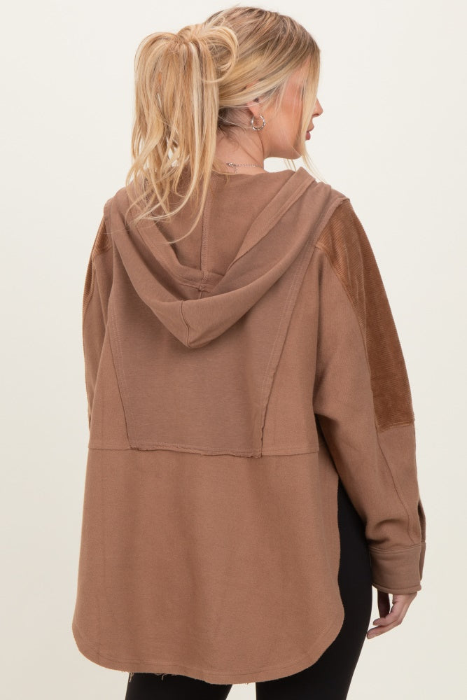 woman wearing a oversized brown hooded sweatshirt with suede shoulder patches, shown from the back
