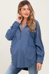 woman wearing a blue maternity pullover with a henley neckline and front pockets, styled with light wash jeans