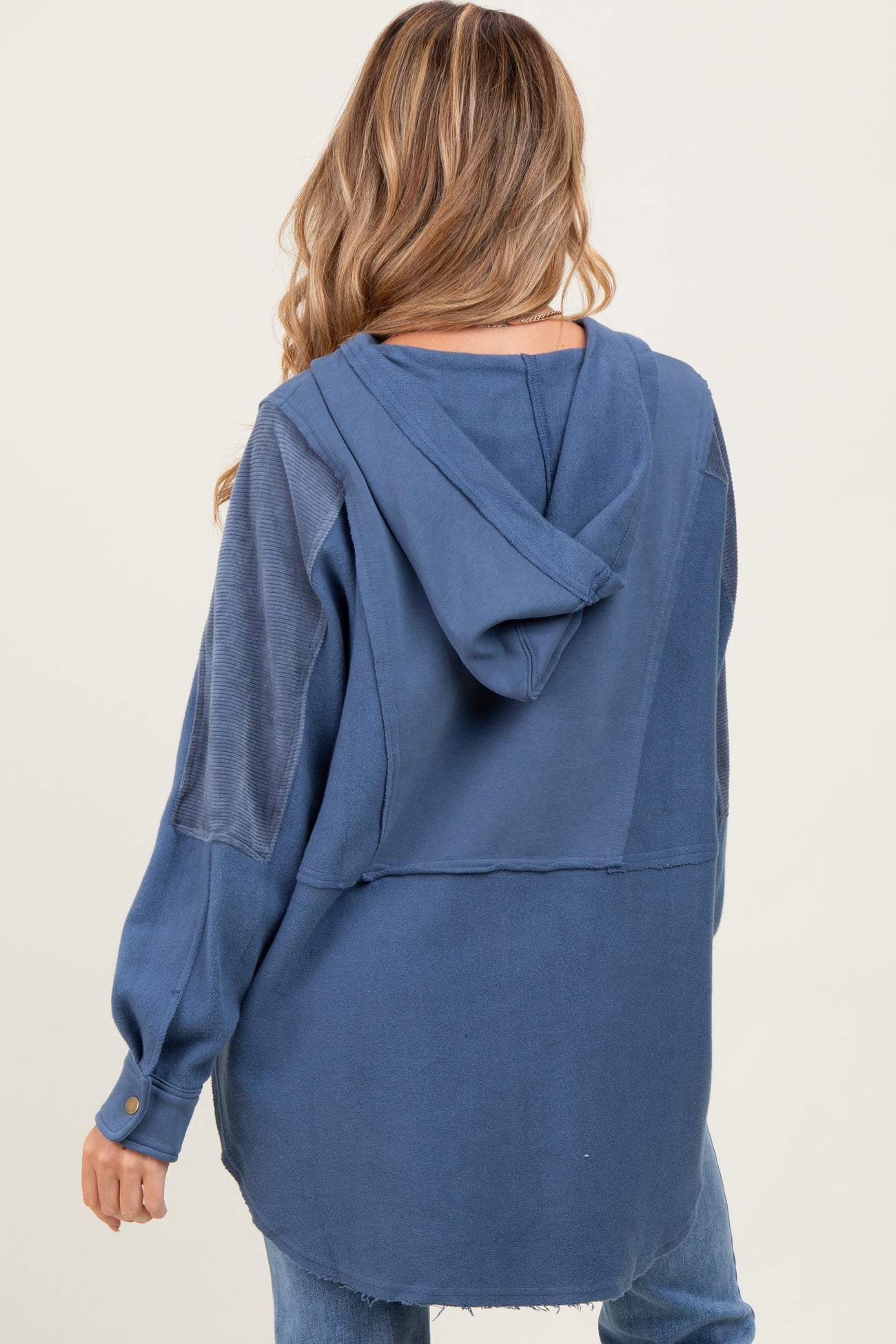woman wearing a blue maternity hoodie with a loose fit and a back hood detail