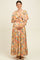 woman wearing a pink floral maternity maxi dress and holding her baby bump