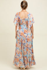 woman wearing a light blue floral maternity maxi dress with flutter sleeves, showing the back view