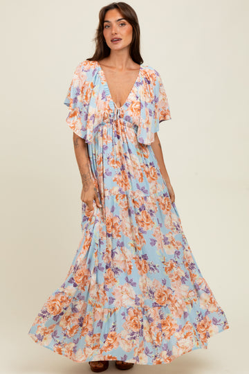 woman wearing a floral maxi dress in light blue with flutter sleeves and a v-neckline