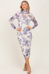 woman wearing a sheer long sleeve floral dress with a mock neck and fitted silhouette