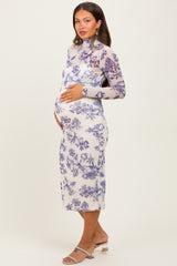woman wearing a sheer long sleeve maternity dress with purple floral print and holding her baby bump