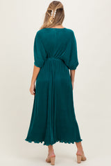 woman wearing a teal maternity dress with half sleeves and an elastic waist, showing a flowing silhouette from the back