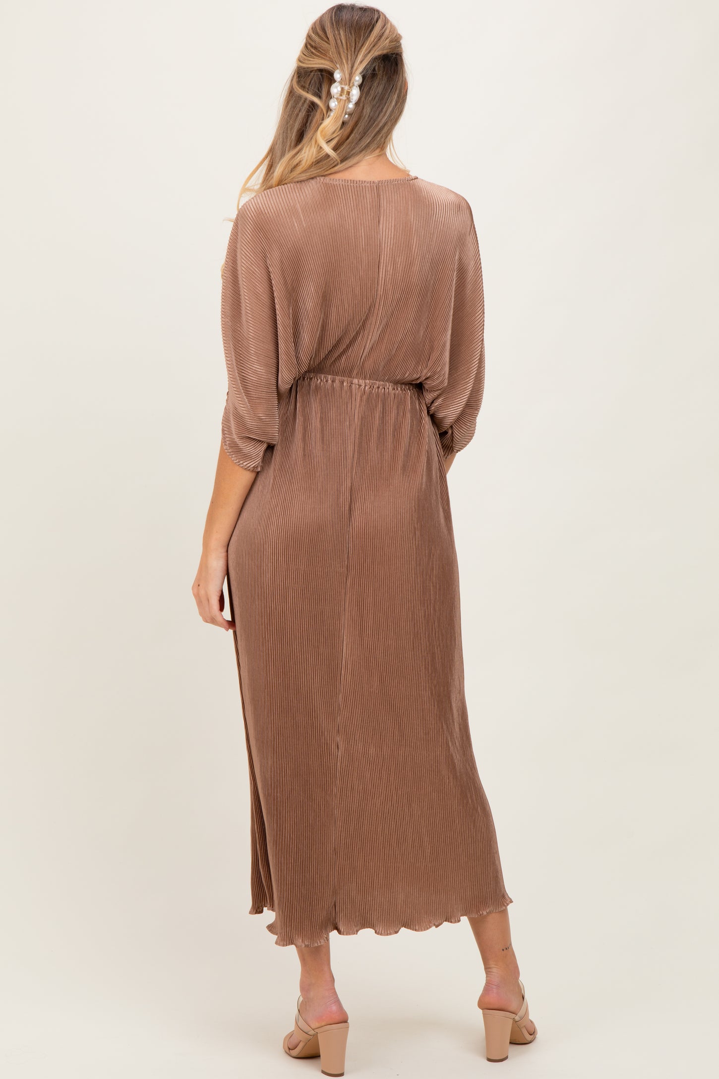 woman wearing a brown ribbed maternity dress with a belted waist and a flowing silhouette