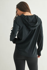 woman wearing a black long sleeve hoodie, shown from the back, paired with black leggings