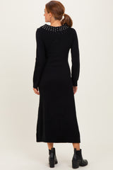 woman wearing a black long sleeve knitted dress with a studded collar and ankle boots, shown from the back