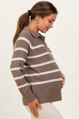woman wearing a brown and white striped maternity sweater, gently cradling her baby bump