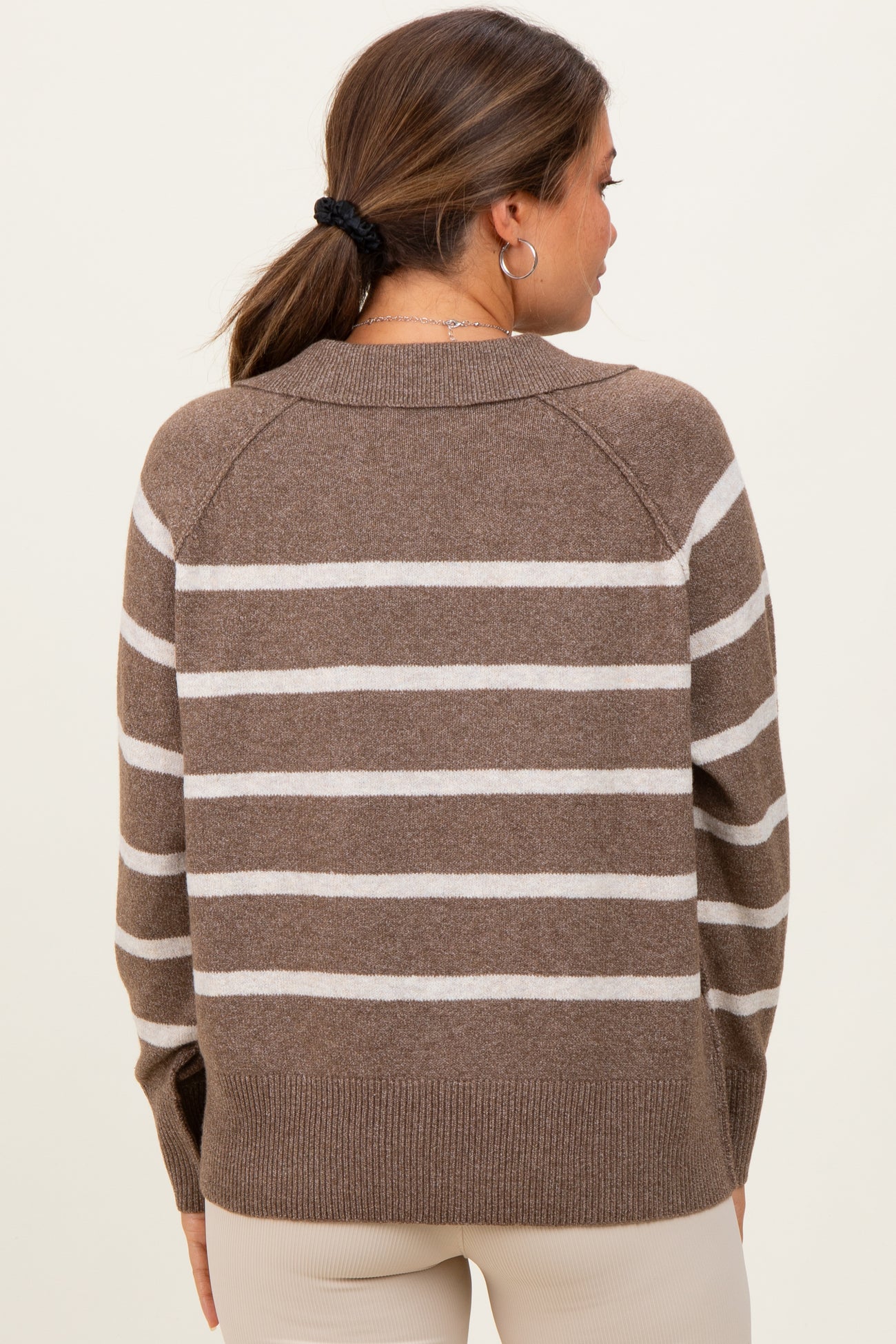woman wearing a brown and cream striped maternity sweater, shown from the back with a relaxed fit