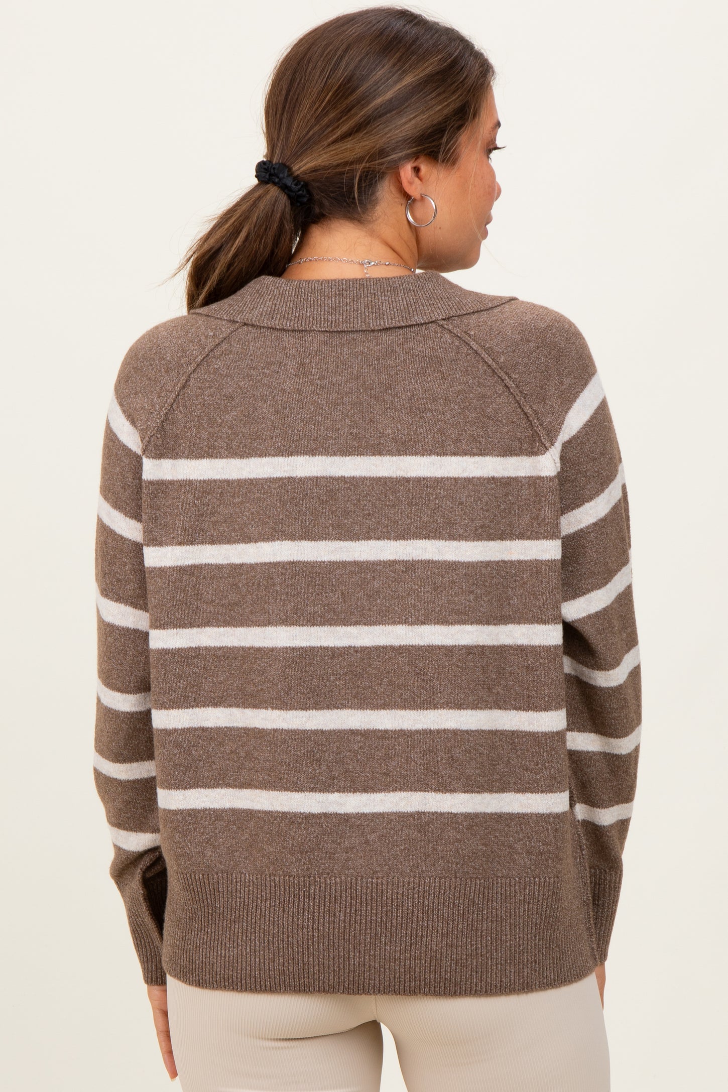 woman wearing a brown and cream striped maternity sweater, shown from the back with a relaxed fit