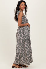 woman wearing a floral print gray maternity maxi dress and holding her baby bump