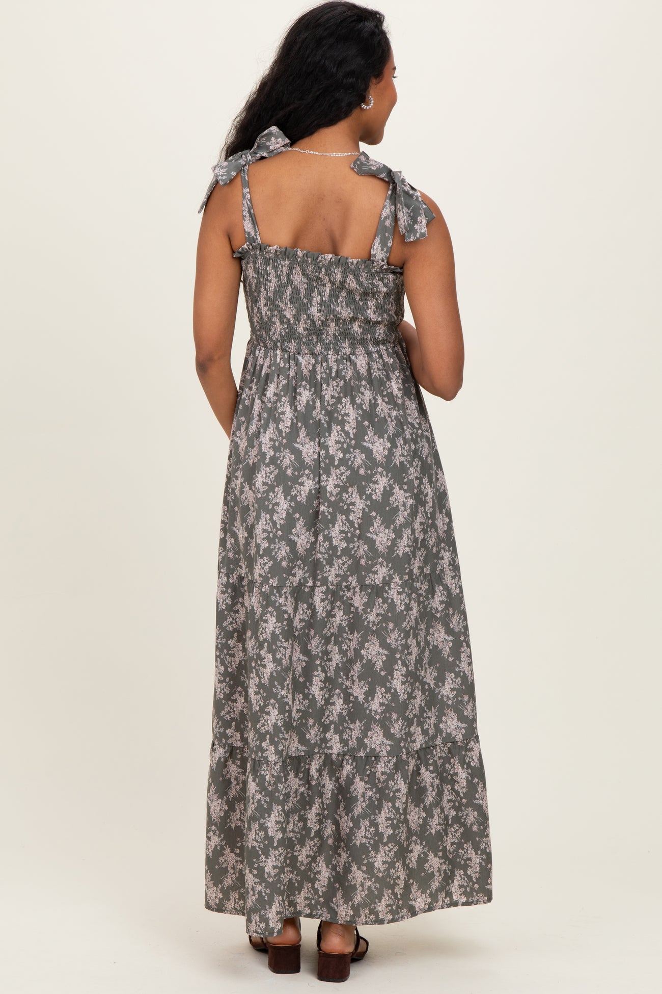 woman wearing a floral print gray maternity maxi dress with tie straps and smocked bodice, showing a baby bump