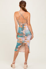 woman wearing a multicolored pastel strappy midi dress with a ruched design and open back detail