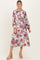 woman wearing a floral print maternity dress with long sleeves and a tied waist, highlighting her baby bump