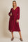 woman wearing a burgundy button-up midi dress with long sleeves and a tied waist detail