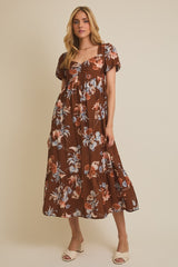 woman wearing a brown floral maxi dress with short puff sleeves and a tiered skirt