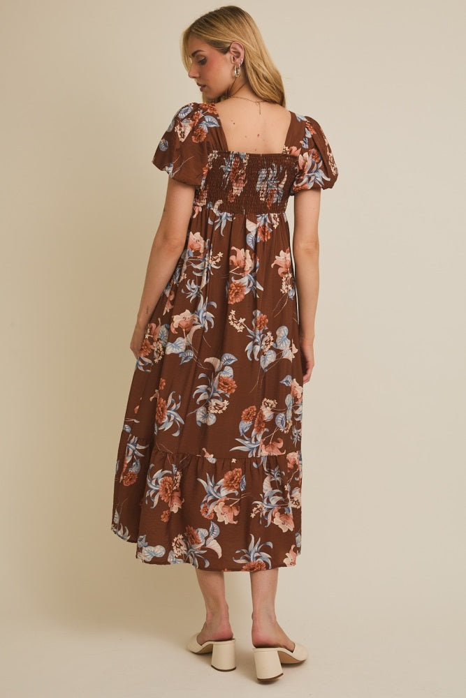 woman wearing a brown floral maxi dress with puff sleeves and a smocked back