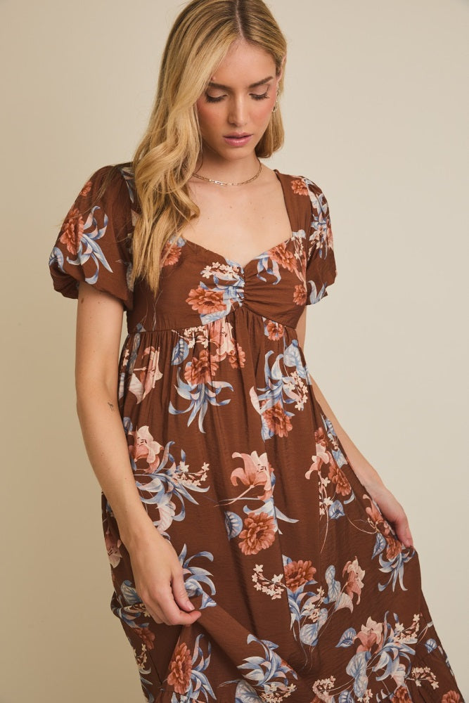 woman wearing a brown floral puff sleeve dress with a square neckline and gathered front detail