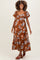 woman wearing a brown floral maternity dress with short puff sleeves and a tie front, showcasing her baby bump