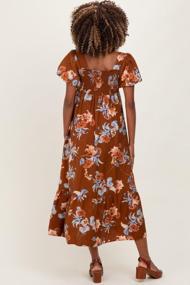 woman wearing a brown floral maternity maxi dress with smocked bodice and short flutter sleeves
