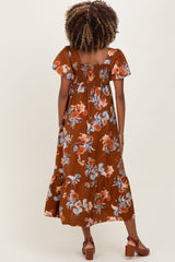 woman wearing a brown floral maternity maxi dress with smocked bodice and short flutter sleeves