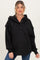 woman wearing a black quilted maternity hoodie with a henley neckline and oversized fit, showing a baby bump