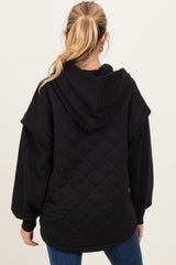 woman wearing a black quilted maternity hoodie with a hood, shown from the back