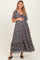 woman wearing a navy blue floral maternity maxi dress and holding her baby bump