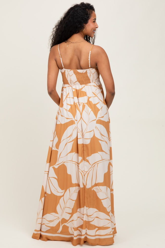 woman wearing a back view of a brown and white floral maternity maxi dress with adjustable straps