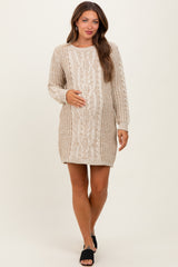 woman wearing a cream cable knit maternity sweater dress and holding her baby bump