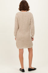 woman wearing a beige knitted sweater dress with long sleeves and a relaxed fit, shown from the back