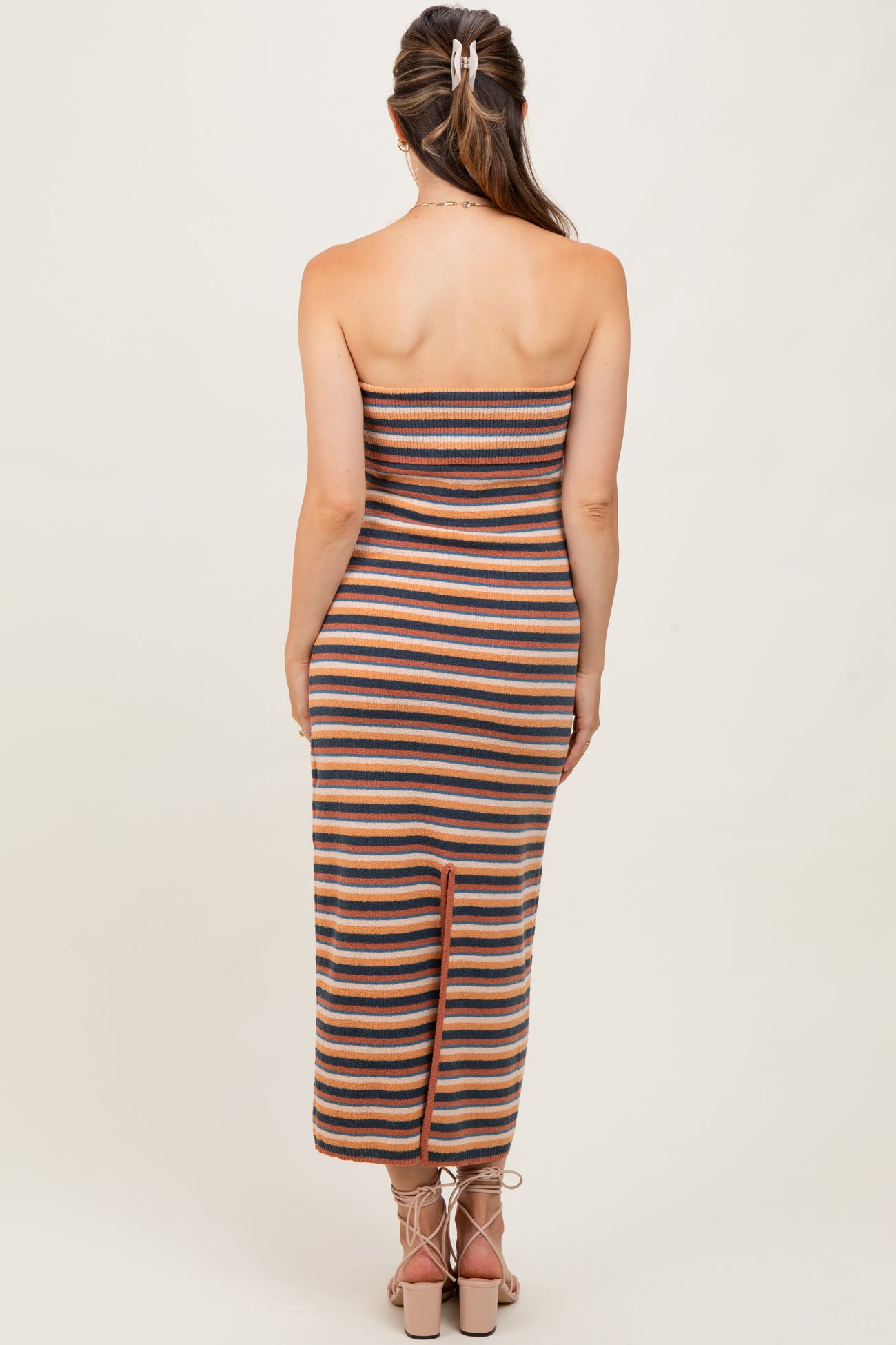 woman wearing a striped strapless maternity dress with a back slit