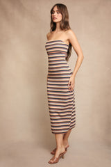 woman wearing a strapless striped midi dress in warm tones with a fitted silhouette