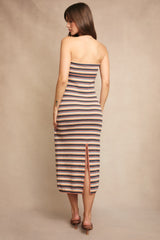 woman wearing a striped strapless midi dress with a back slit and fitted silhouette