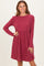 woman wearing a burgundy long sleeve ribbed dress with a flared skirt and round neckline