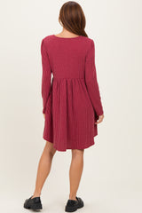 woman wearing a burgundy striped long sleeve dress with a flared skirt and a scoop back view