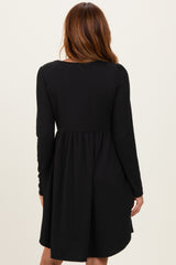 woman wearing a black ribbed long sleeve dress with a flared skirt, viewed from the back