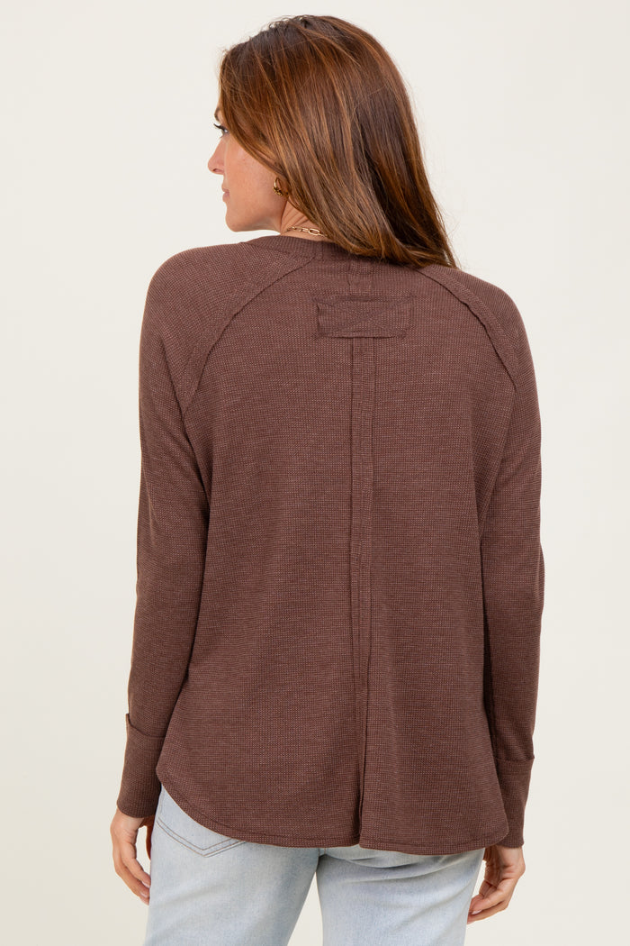 woman wearing a brown long sleeve top with a relaxed fit and a back seam detail