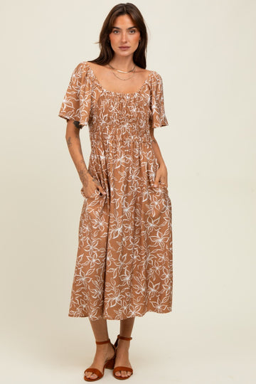 woman wearing a brown floral midi dress with short sleeves and pockets