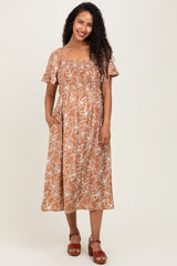 woman wearing a brown floral print maternity dress with short sleeves and pockets