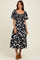woman wearing a black and white floral print midi dress with a square neckline and short puff sleeves