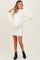 woman wearing a ribbed cream maternity sweater dress, displaying her baby bump, paired with black ankle boots