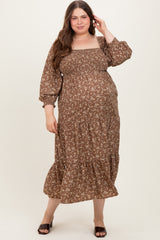 woman wearing a brown floral maternity dress with a smocked bodice and bell sleeves, showcasing her baby bump