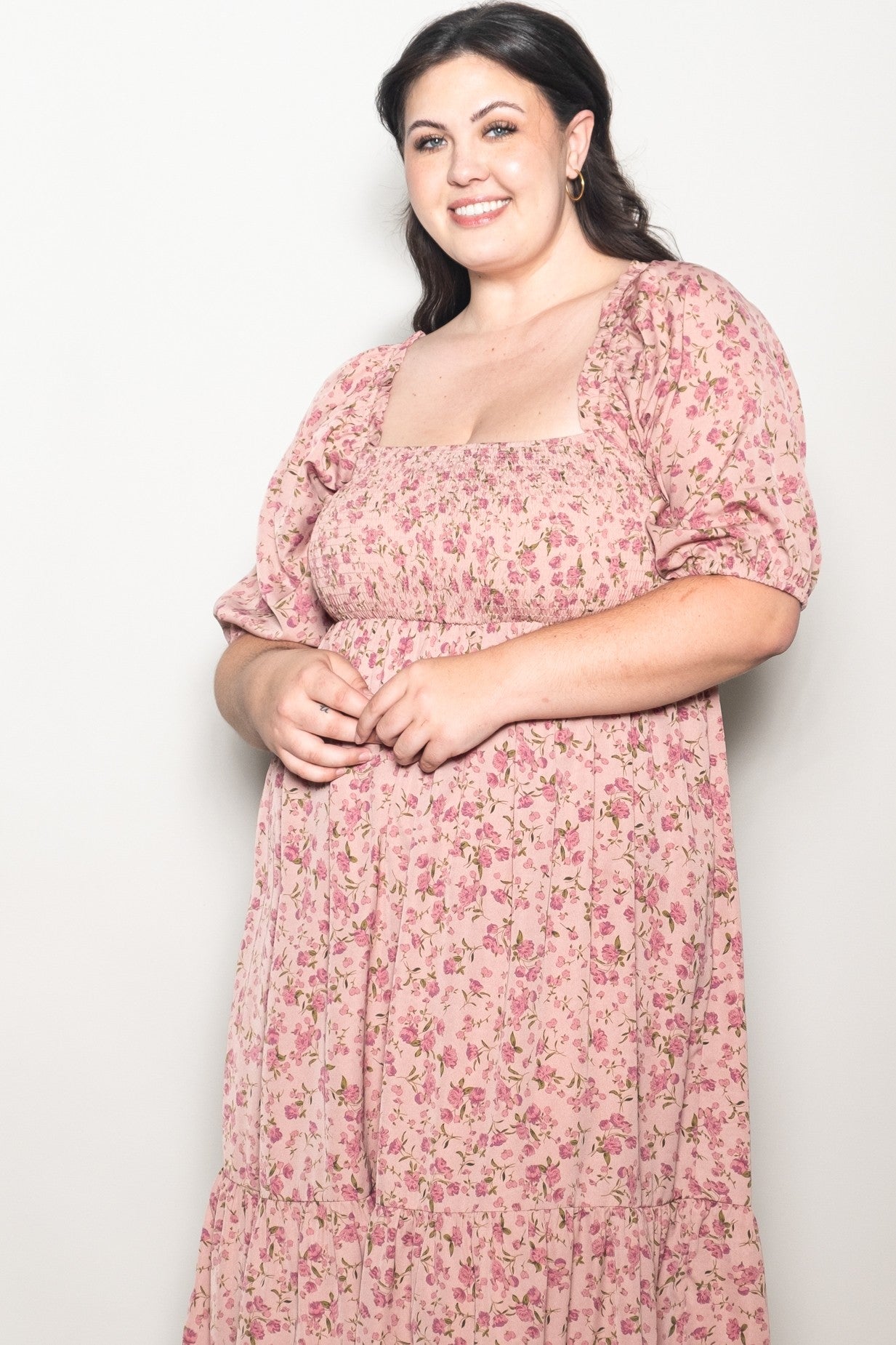 woman wearing a pink floral plus-size maxi dress with puff sleeves and a square neckline