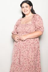 woman wearing a pink floral plus-size maxi dress with puff sleeves and a square neckline