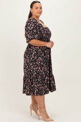 woman wearing a black floral plus-size midi dress with short sleeves and a ruffled hem