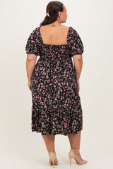 woman wearing a black floral plus-size dress with puff sleeves and a tiered hem, viewed from the back