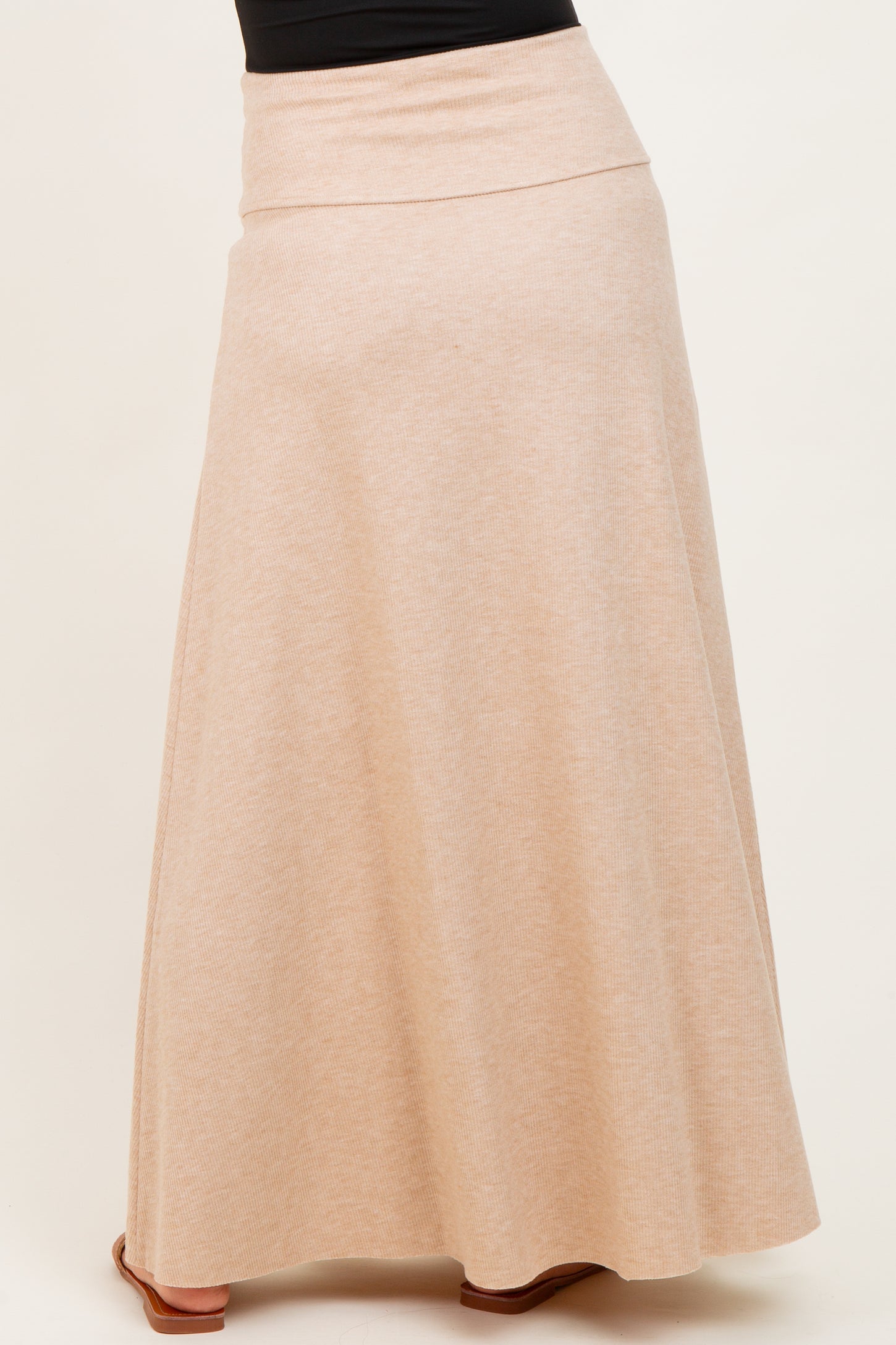 woman wearing a beige maternity maxi skirt with a comfortable waistband and flared hem