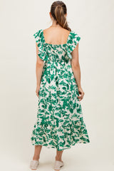 woman wearing a green floral print maternity maxi dress with ruffled sleeves and smocked back detail